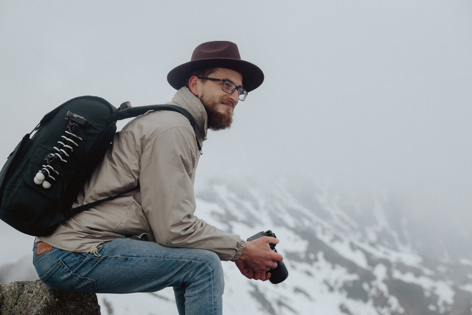 A Man Sitting While Carrying a Backpack