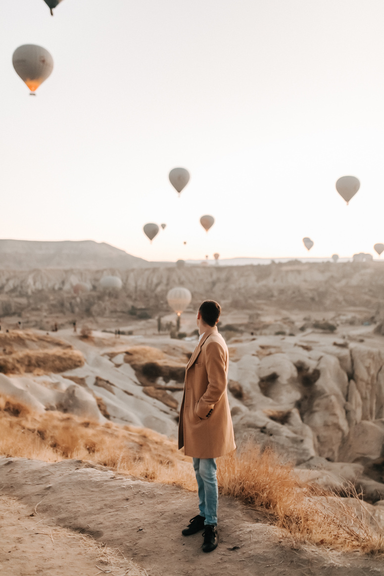 A Man Looking at Hot Air Balloons Flying 